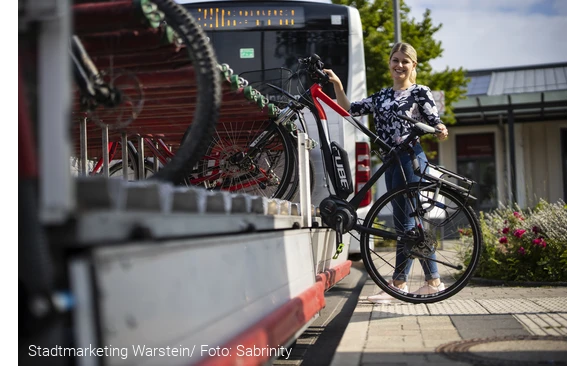 Das Fahrrad wird auf den Anhänger des Busses aufgeladen.