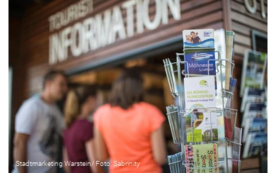 Tourist-Information legt Prospekte und Kartenmaterial aus.
