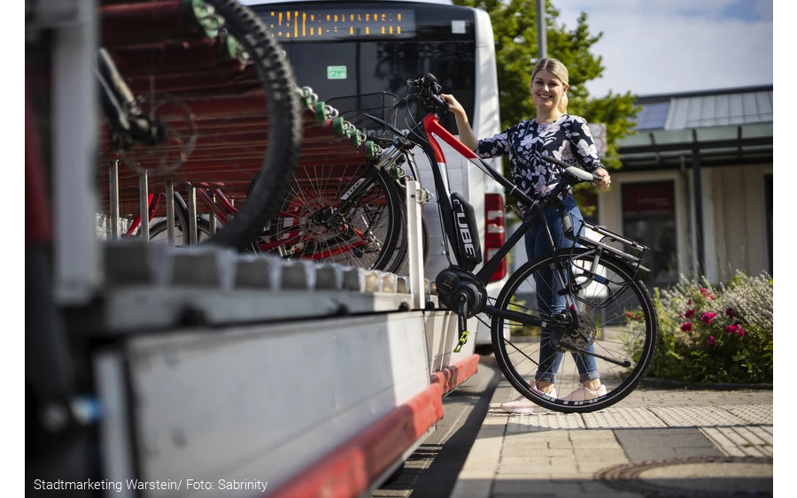 Das Fahrrad wird auf den Anhänger des Busses aufgeladen.