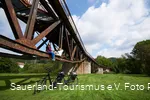 Zwei Radfahrer sitzen auf der Fischbauchbrücke Foto: Paul Masukowitz